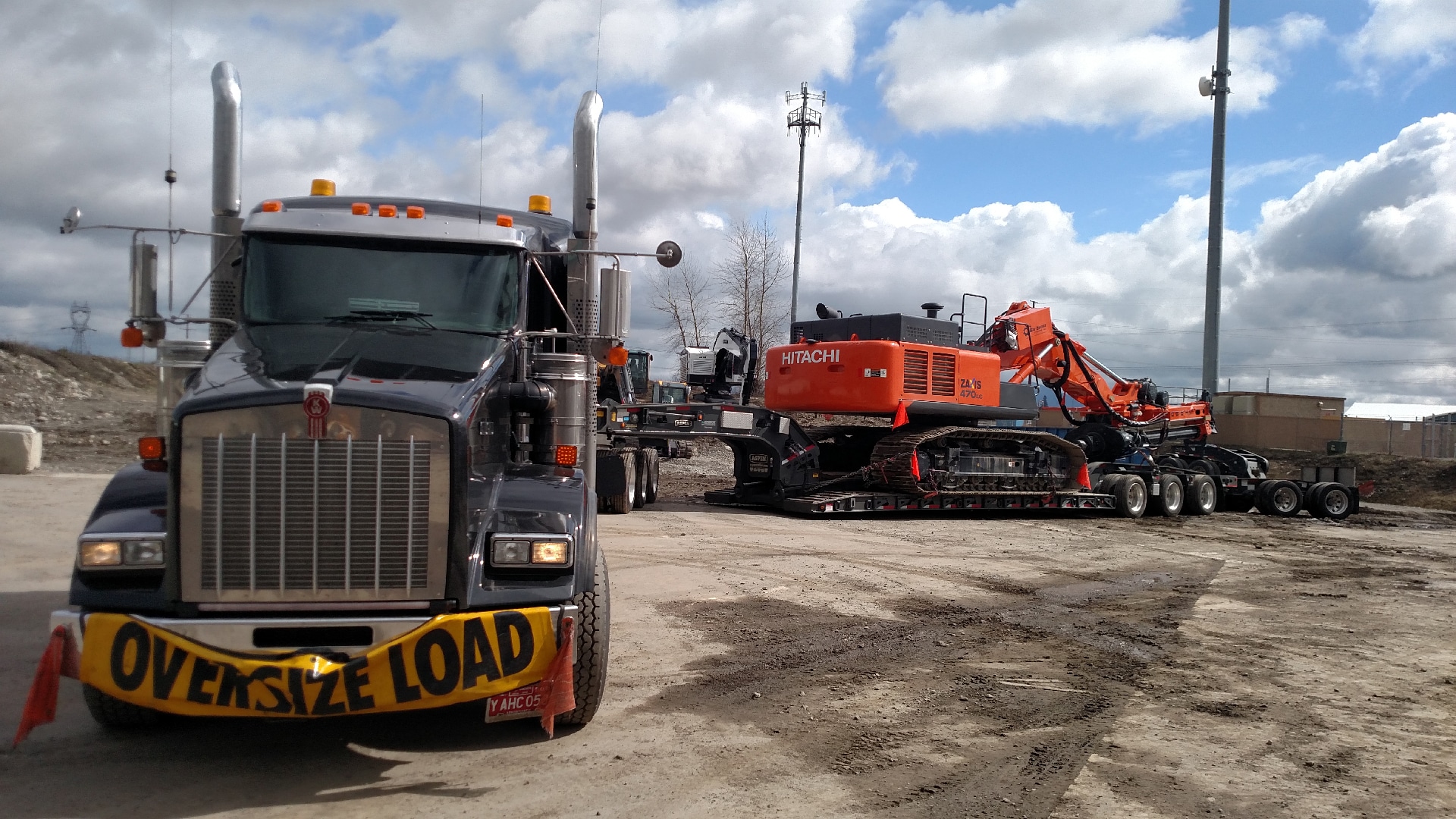 Oversize load truck hauling construction equipment.